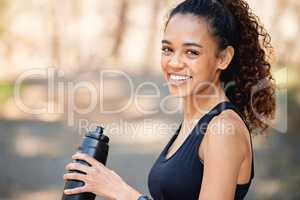 Helping my body achieve greatness. a young woman drinking water during a run.