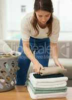 The sweet ending of chore day. a young woman doing laundry at home.
