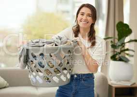 clean laundry hypes her up. a young woman doing laundry at home.