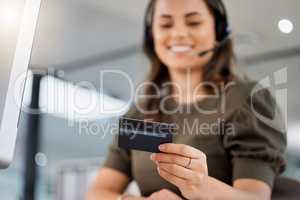 Ill quickly collect your info. a young female call center agent holding a credit card at work.