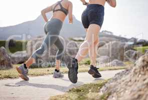 Friendship and fitness goals. Rearview shot of two women going for a run in a park.