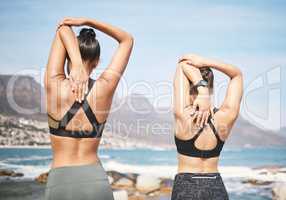 The way you warmup is important. Rearview shot of two unrecognizable athletic young women warming up before a wrokout on the beach.