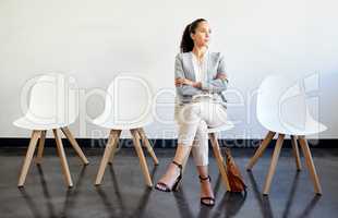 The bigger the dream, the bigger the success. a young businesswoman waiting in line at an office.