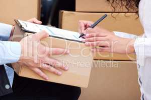 You have to sign before we can hand over. a customer signing for her delivery from the courier.