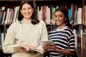 Invest time into your education. two young female students doing research in a library at college.