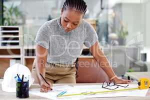 Consistency is the only way to improve a skill. a female contractor drawing up blueprints.