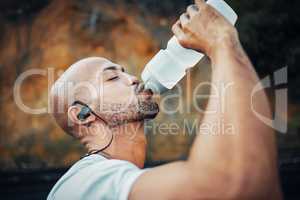 To be successful, you must dedicate yourself 100. a sporty young man drinking water while exercising outdoors.