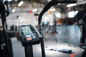 Choose a speed that challenges you. Closeup shot of an exercise bike in a gym.