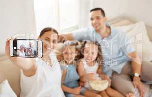 Spending quality time with the family. a woman taking a selfie at home with her family.