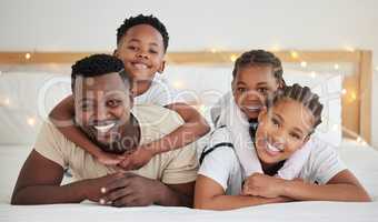 Nothing like childrens gratitude and womans love. a beautiful young family bonding in bed together.