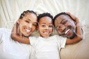 Having parents is a blessing. a beautiful young family bonding in bed together.