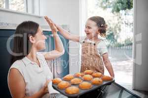 I guess its flop-proof after all. a woman sharing a high-five with her daughter while baking.