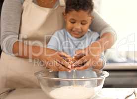 Gently, gently darling. an adorable little boy baking with his mom at home.