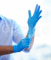 Get those gloves on and get to work. an unrecognisable dentist putting on rubber gloves.
