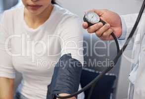 I have to check your blood pressure before the procedure. a doctor examining a woman with a blood pressure gauge.