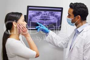 This is why youre experiencing pain in that area. a dentist discussing the results of a patients teeth x ray.