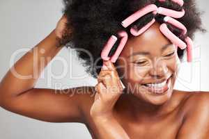 My hair loves this. a young woman styling her hair against a grey background.