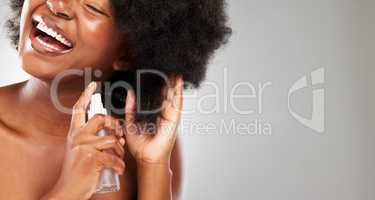 My hair loves the moisture. a young woman styling her hair against a grey background.