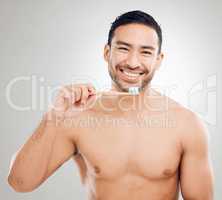 Take care of your teeth, you only get one set. Studio shot of a handsome young man brushing his teeth against a grey background.