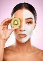 Healthy skin comes from within. Studio shot of an attractive young woman holding kiwi fruit to her face against a pink background.