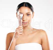 Pick your brush. Studio portrait of an attractive young woman posing with makeup brushes against a grey background.