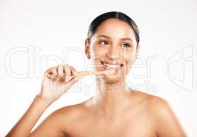 Thinking about dental hygiene. Studio shot of an attractive young woman brushing her teeth against a grey background.