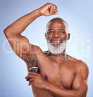 Natural doesnt have to mean stinky. Studio portrait of a mature man applying deodorant to his armpit against a blue background.