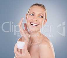 Protect your skin so it can protect you. Studio shot of an attractive young woman applying lotion to her face against a grey background.