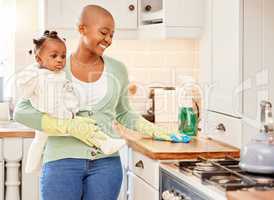 Its chore day. an attractive young woman carrying her daugher while doing chores at home.