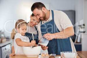 Love lives here and you can smell it. a young couple and their daughter baking together at home.