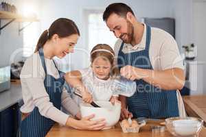 Made with love by the whole family. a young couple and their daughter baking together at home.