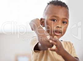 Boo boos happen, band aids help. an adorable little boy applying a bandaid to his arm.