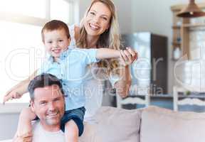 Whatever you call it, you need family. two parents playing with their son at home.