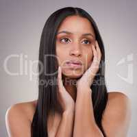 I could really use a change in style. an attractive young woman standing alone and looking contemplative while posing in the studio.