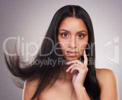 Channel your inner diva. an attractive young woman standing alone and looking contemplative while posing in the studio.