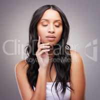 Confidence comes from having great hair. an attractive young woman posing alone in the studio.