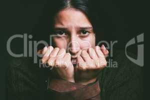 My mind is holding me hostage. a young woman looking scared with a belt tied around her arms against a black background.