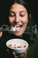Dont let your diet goals consume you. a young woman eating a bowl full of pills.