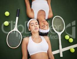 Play hard but rest just as hard. two tennis players lying next to each other.