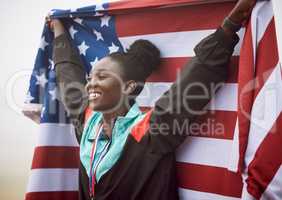Shes a national hero. an attractive young female athlete celebrating a victory for her country.