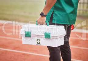 Hes ready for any emergency. Rearview shot of an unrecognizable male paramedic standing outside on a track with his first aid kit.