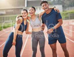 Having a blast out on the track. three young athletes standing outside together on the track.