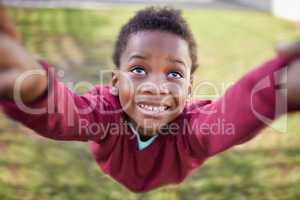 The crazy, carefree days of youth. an adorable little boy being swung by his hands in a garden.