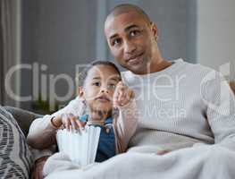 Look, its bear theyre looking for. a father and daughter eating popcorn while watching television together at home.