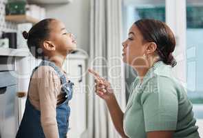 When you choose the behaviour, you choose the consequence. a little girl being spoken to sternly at home by her mother.