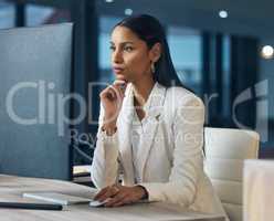 Hows the stock market looking today. an attractive young businesswoman sitting alone in her office at night and looking contemplative while using her computer.