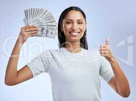 Let me show you how to make money, fast. a young woman showing thumbs up while holding up bank notes against a grey background.