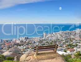 Scenic landscape banner view of a public bench on a cliff or hill overlooking the city and the ocean. Empty, peaceful, and quiet natural area with a seat for relaxation in nature with copyspace