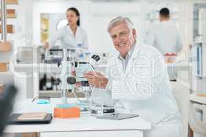 Science is the main tool to explore the hidden secret of world. Portrait of a senior scientist using a microscope in a lab.