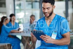 Dont doubt your abilities. a young male nurse using a digital tablet during a meeting.